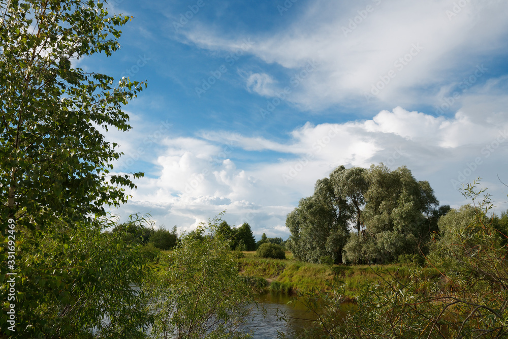 Obraz premium cloudy clouds over the river in summer
