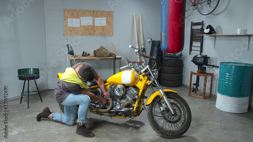 Man can’t fix a motorcycle part in a garage