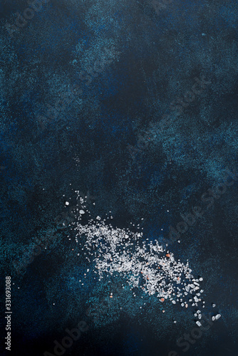 Sea salt sprinkled on a blue textured background