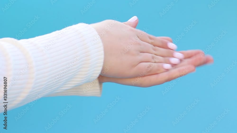 Woman pours and washes his hands on blue background sanitayzery side view. Woman pours and washes his hands on blue background sanitayzery side view.