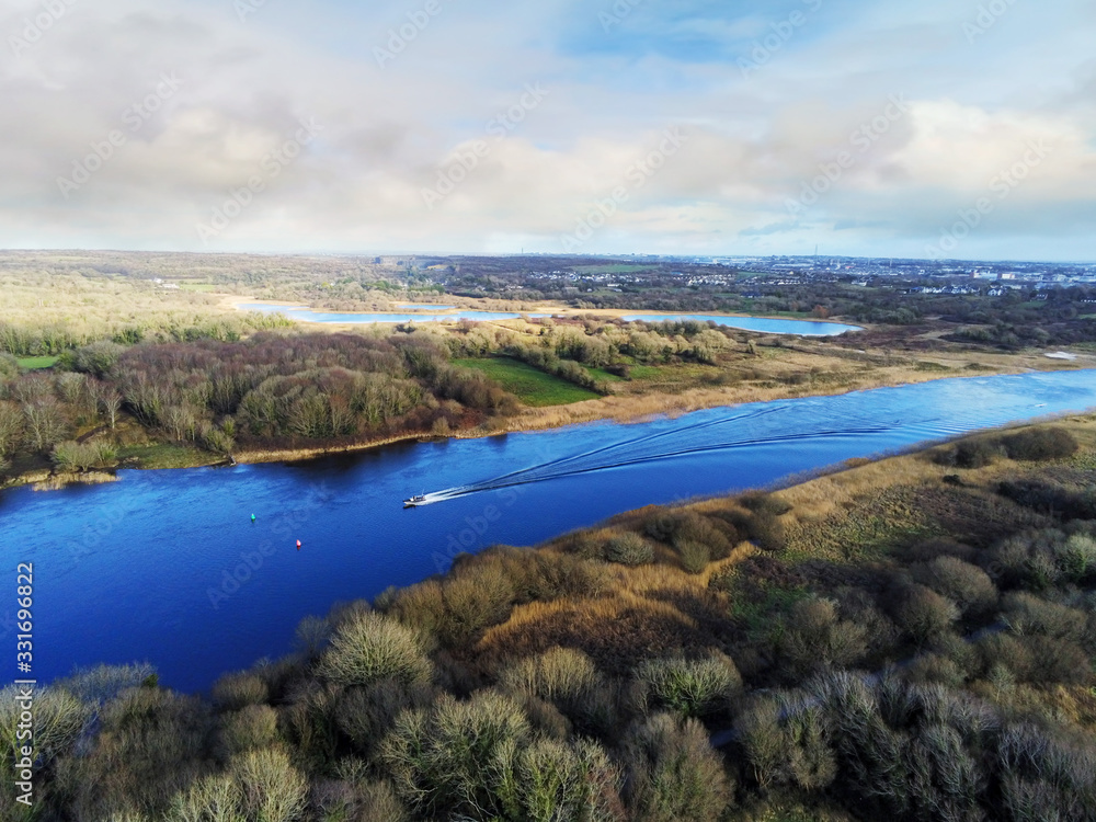 Aerial view on River Corrib, county Galway, Small fishing boat on water, blue cloudy sky. Warm sunny day.