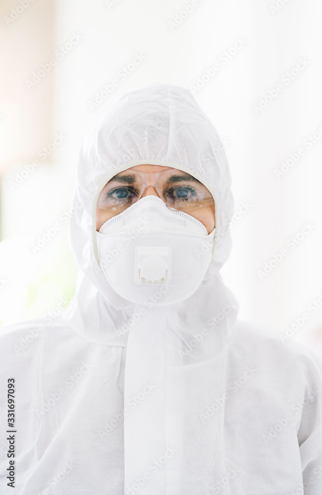 Portrait of protected woman with safety suit, glasses and mask before a pandemic or virus Portrait of protected woman with safety suit, glasses and mask before a pandemic or virus