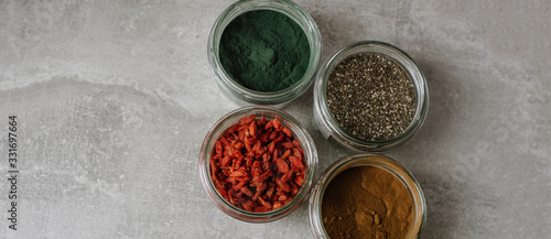 Dried goji berries, chia seeds, spirulina, carob in a close up view