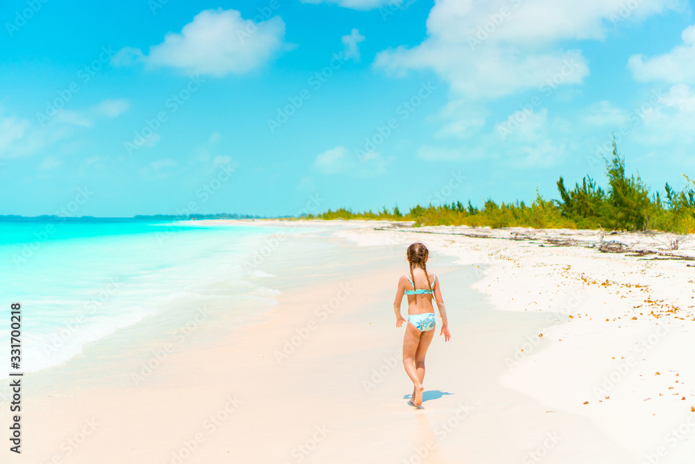 Adorable little girl have fun at tropical beach during vacation Adorable little girl have fun at tropical beach during vacation