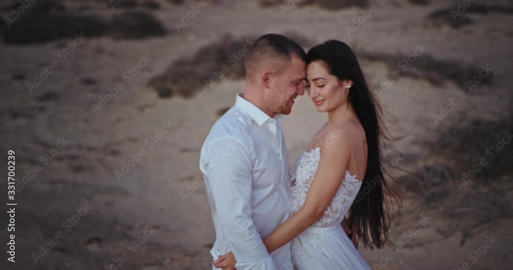 Attractive romantic couple in love have a perfect time in the middle of nature with full of sand field they hugging each other Attractive romantic couple in love have a perfect time in the middle of nature with full of sand field they hugging each other