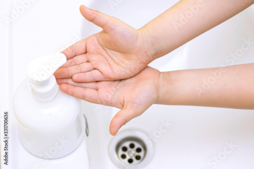 childrens hands are washed. children hand reaches for antibacterial soap. Protection against bacteria  coronavirus. hand hygiene.