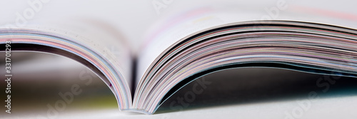 Colorful pages of an open magazine, close up. Selective focus. photo