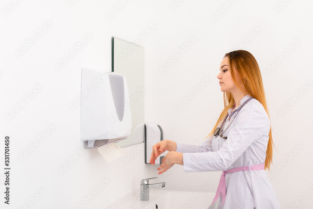 Young female doctor washing her hands befor patient admission in new clinic office. Helthcare concept Young female doctor washing her hands befor patient admission in new clinic office. Helthcare concept