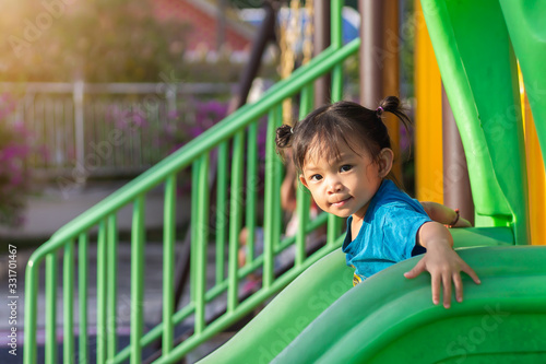 Portrait image of 2-3 yeas old baby. Happy Asian child girl smiling and laughing. She playing with slider bar toy at the playground. Learning and active of kids concept. © waridsara