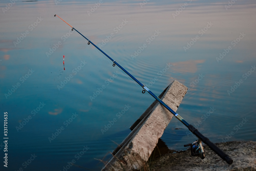 A fishing line is fishing near a blue lake A fishing line is fishing near a blue lake