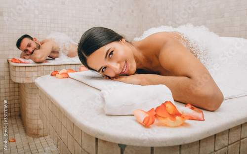 Beautiful woman and her boyfriend enjoy a Turkish bath. Hot steam warmed the bodies of a man and a woman in a hammam photo