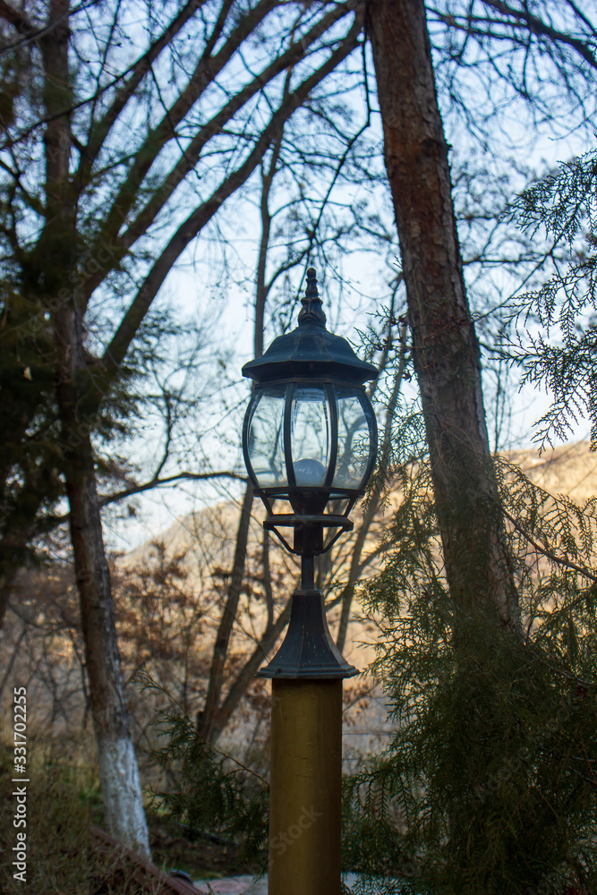 old lantern in the park on landscape background