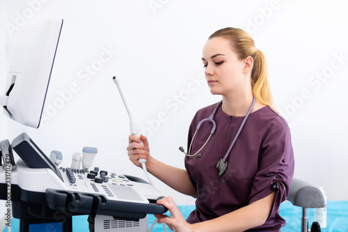 Ultrasound special sensor of modern ultrasonic scanner for intavaginal checkup and small medical condom for it in young woman doctor's hands preparing for a device scan. Helthcare concept photo