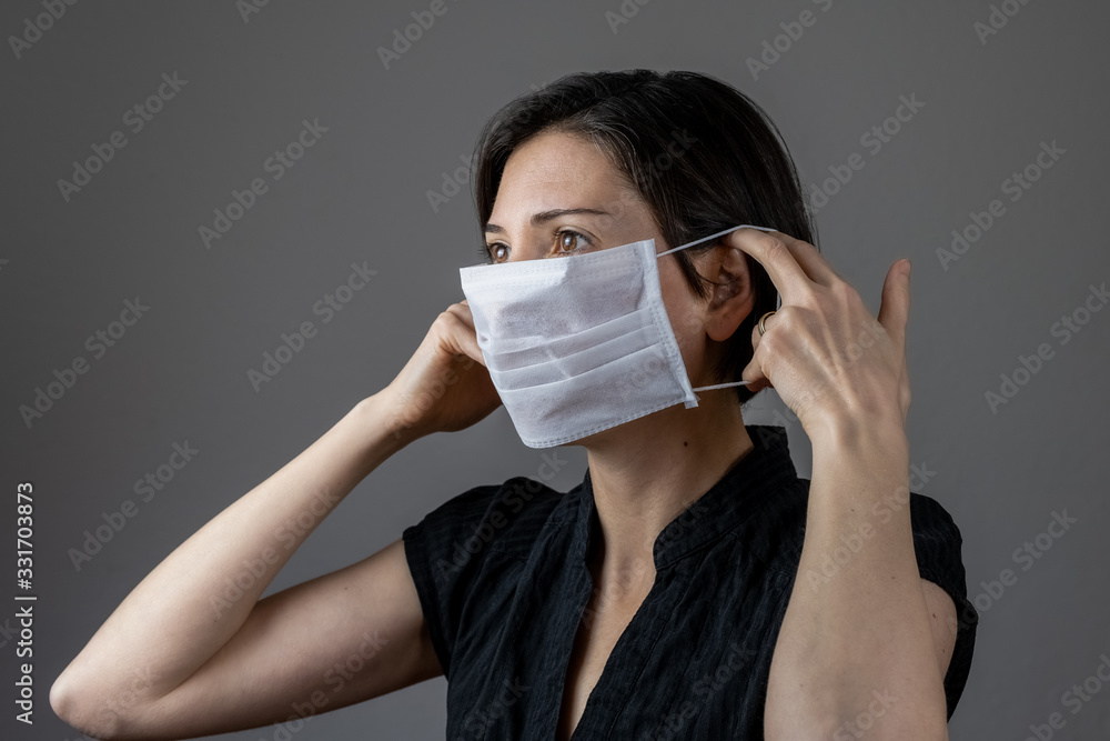 Caucasian woman wearing a white medical mask for protection against contagious disease, coronavirus Caucasian woman wearing a white medical mask for protection against contagious disease, coronavirus