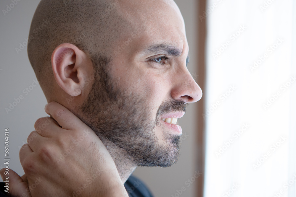 Obraz premium Caucasian young man with neck and shoulder pain. Auto massage for muscle injury. Isolated human. Neck therapy needed. Isolated human touching neck. Sore Spine
