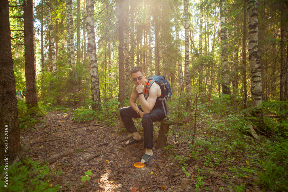 Handsome man resting on bench in spring forest Handsome man resting on bench in spring forest