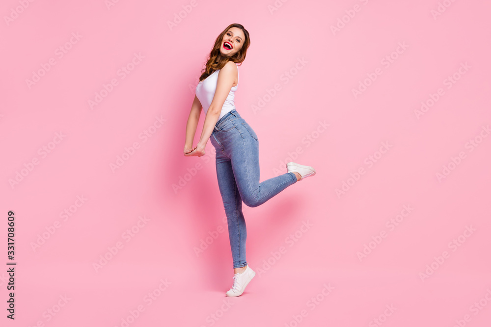 Full body profile photo of funky lady walk down street cool trend look summer warm hot weather wear white tank-top jeans footwear isolated pink bright color background