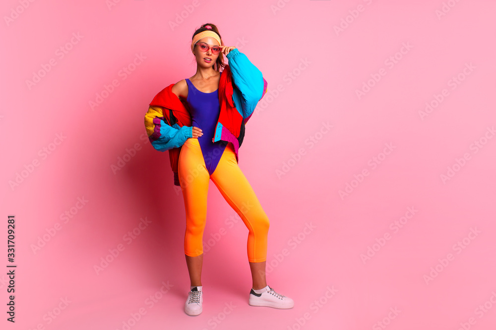 Full length image of 80's Fashion woman over pink background. Beautiful athletic girl in 80s style sportswear, fashionable in bright body suit Stock-foto | Adobe Stock