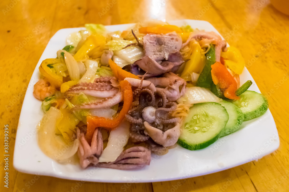 Grilled squid and cuttlefish with cucumbers and vegetables on a plate