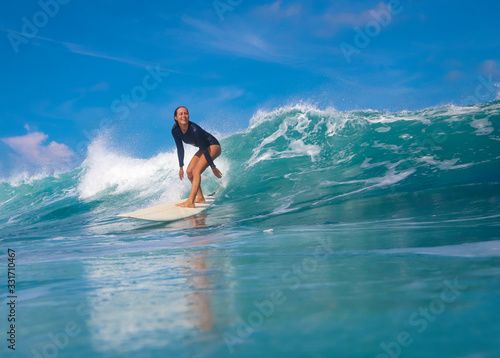 Female surfer on a blue wave