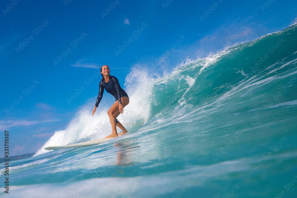 Female surfer on a blue wave