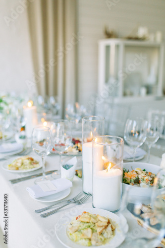 Light decor in the style of fine art. Glasses and tulips in the composition. Table setting for a feast. Wedding table decor in the white Studio.