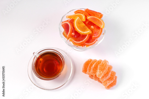 a Cup of tea and citrus marmalade in a candy bowl on a white background