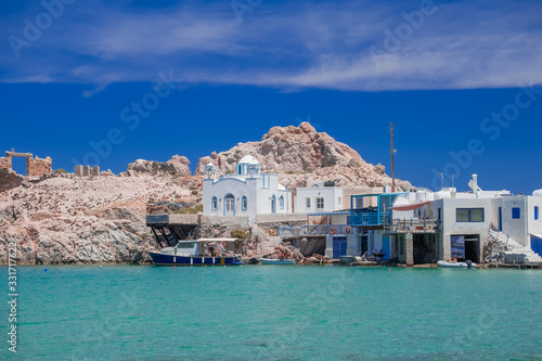 Mandrakia traditional fishing village with syrmata. Orthodox church and boat garages on Aegean sea, Milos island. Mediterranean plants and greek architecture. Greece paradise vacation photo