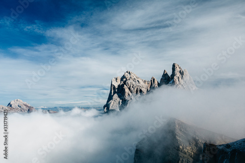 View from Seceda, Odle mountains in the fog, over the clouds. Amazing unique views in Dolomites mountains, Italy, Europe. © pmartike