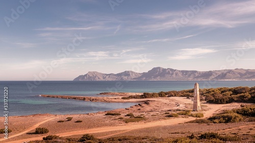 Watchtower Santa Margalida with sea and blue skies, mountains in the distance, located between Can Picafort and Son Serra De Marina,mallorca,Spain.