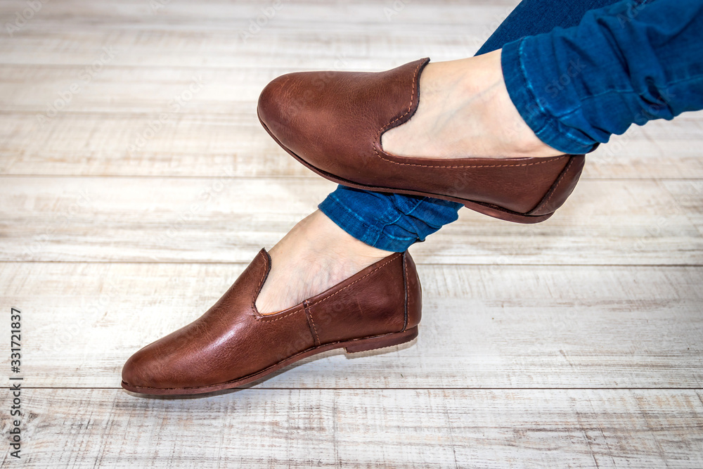 Isolated female brown leather shoes on wood background Isolated female brown leather shoes on wood background
