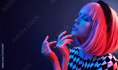 Portrait of young girl with blond hair in red and blue neon in studio