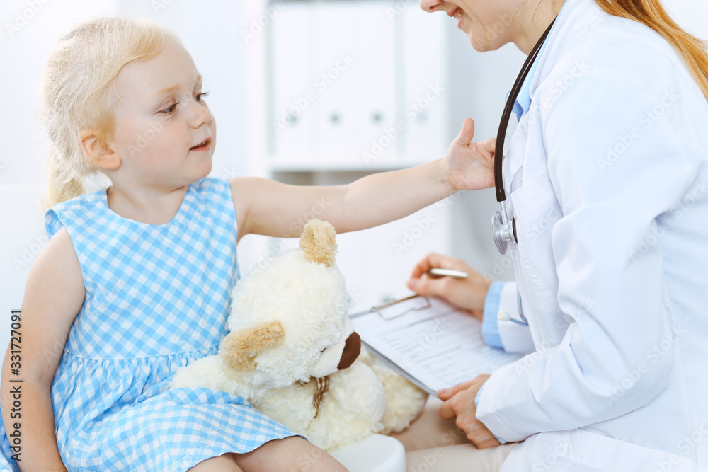 Happy smiling child patient at usual medical inspection. Doctor and patient in clinic. Medicine, healthcare concepts Happy smiling child patient at usual medical inspection. Doctor and patient in clinic. Medicine, healthcare concepts