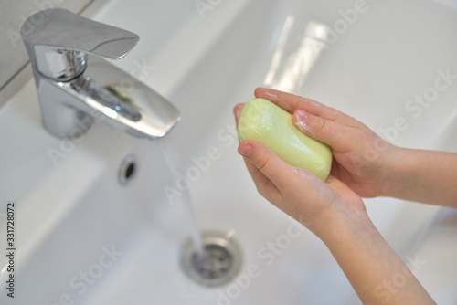 Close up of hands washing with soap. Washing hands with soap under the faucet with water. Clean and hygiene concept.