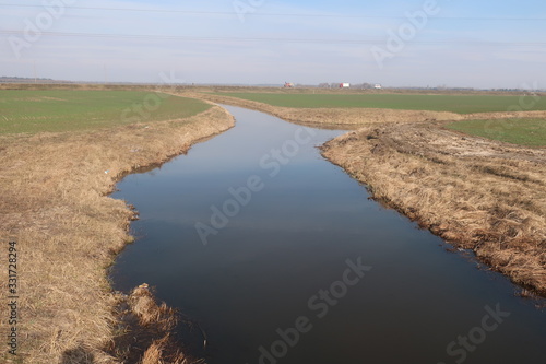  beautiful river on a background of blue sky and green field