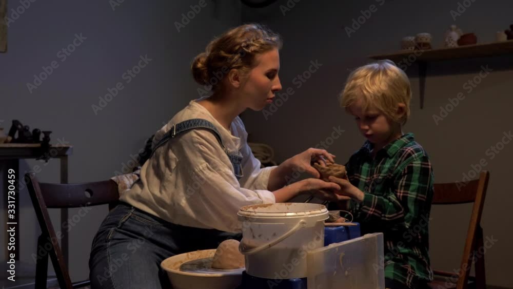 Woman helps boy to sculpt in the workshop Woman helps boy to sculpt in the workshop