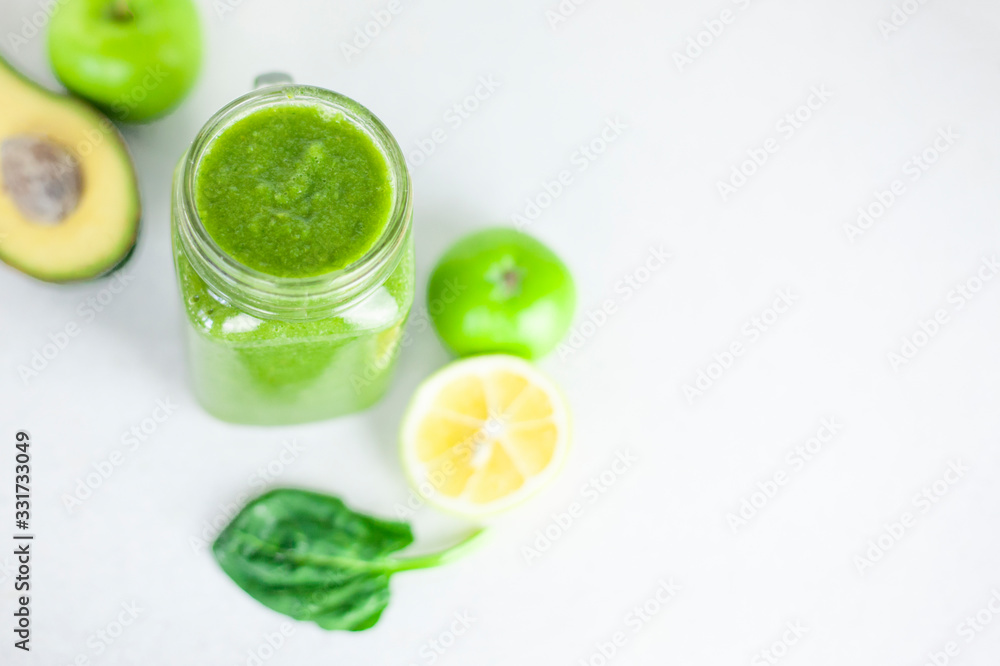 glass of green smoothie detox drink and a set of products for preparation: lemon, apple, avocado, spinach. Morning detox for a healthy lifestyle, weight loss, ketone diet, raw food diet glass of green smoothie detox drink and a set of products for preparation: lemon, apple, avocado, spinach. Morning detox for a healthy lifestyle, weight loss, ketone diet, raw food diet