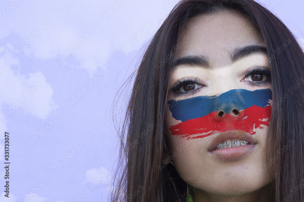 Flag of Russia painted on a face of a smiling russian young woman. Copyspace.