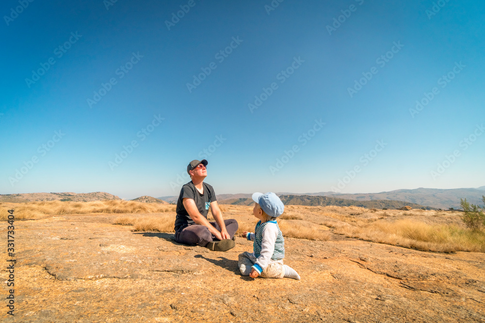 Father enjoying sun while playing with baby son outdoor Father enjoying sun while playing with baby son outdoor