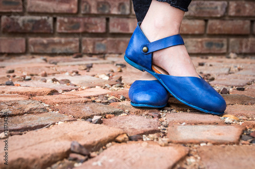 Isolated blue leather shoes on paving texture background outdoors