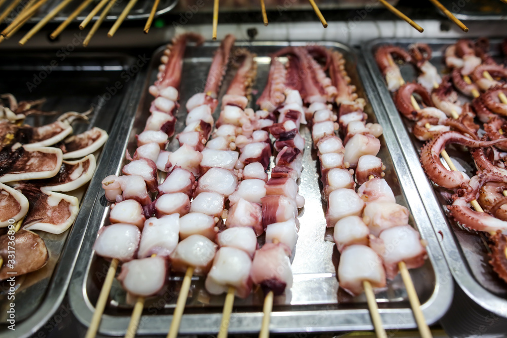 Octopus on wooden sticks for grilling.