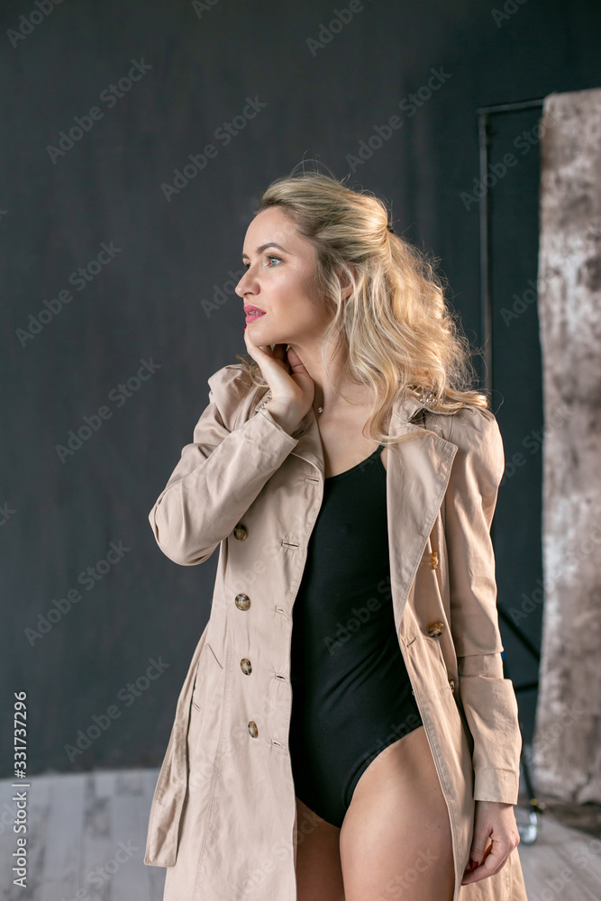vertical portrait of a gorgeous blonde in a black leotard and a beige cloak vertical portrait of a gorgeous blonde in a black leotard and a beige cloak
