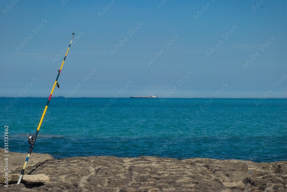 Fishing rod on a high rock, on the seashore. Fishing rod on a high rock, on the seashore.