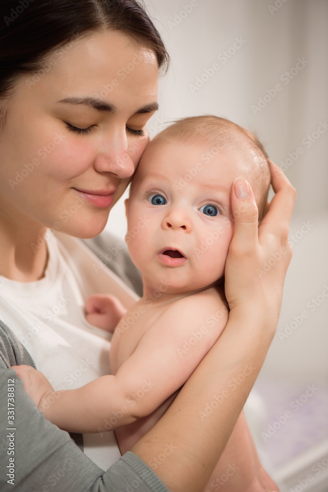 Close up portrait of beautiful young mother girl kissing her newborn baby Close up portrait of beautiful young mother girl kissing her newborn baby