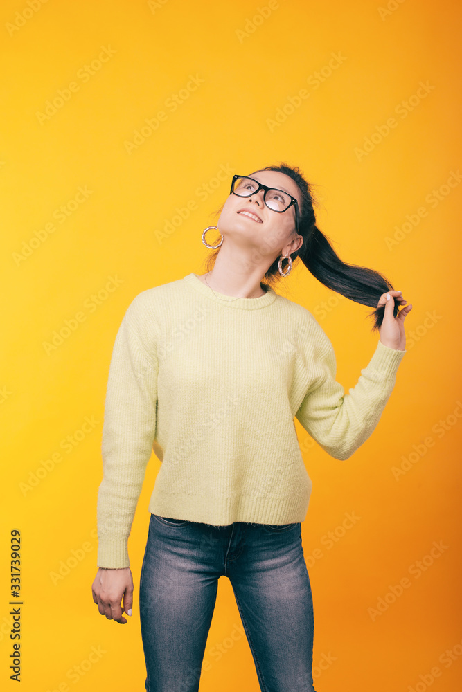 Portrait of cheerful trendy asian woman standing over yellow background Portrait of cheerful trendy asian woman standing over yellow background
