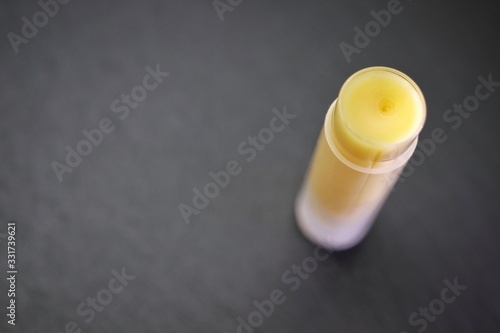 Extreme closeup of beeswax homemade lip balm on dark gray background. Macro with shallow DOF, top view.
