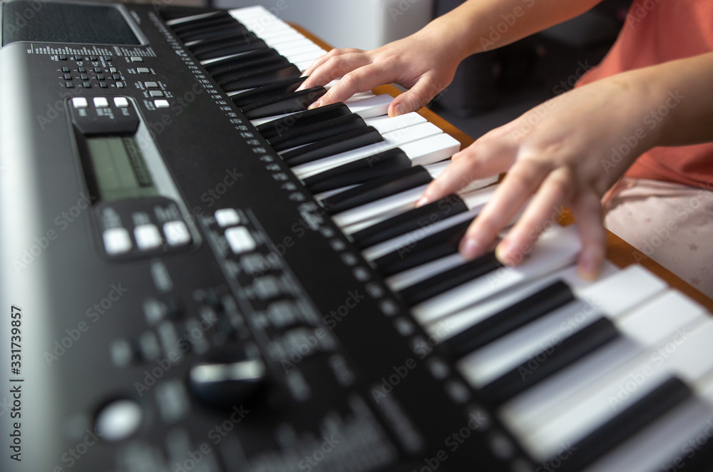 Young female beginner teaches itself playing on the electric piano, instrument playing, teachning Young female beginner teaches itself playing on the electric piano, instrument playing, teachning