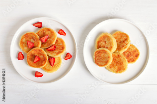 Cottage cheese pancakes with strawberry, syrniki on white background