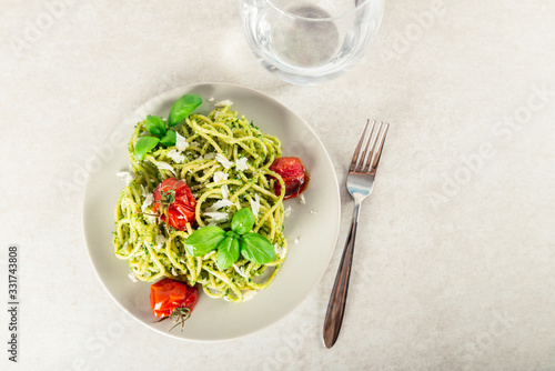 Pasta spaghetti with homemade pesto sauce, roasted tomatoes and fresh basil leaves, vegetarian food