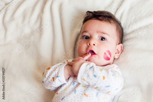 cute newborn baby with lipstick mark in his cheek